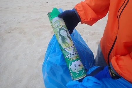 中国語のラベルが残ったスプレー缶を拾い上げるメンバー