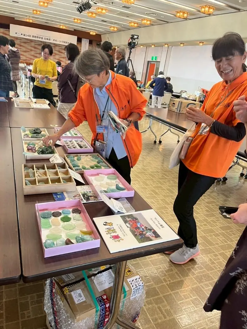 漂着物学会の会場で、浜で拾った海ガラスを並べて紹介する海謝美のメンバー